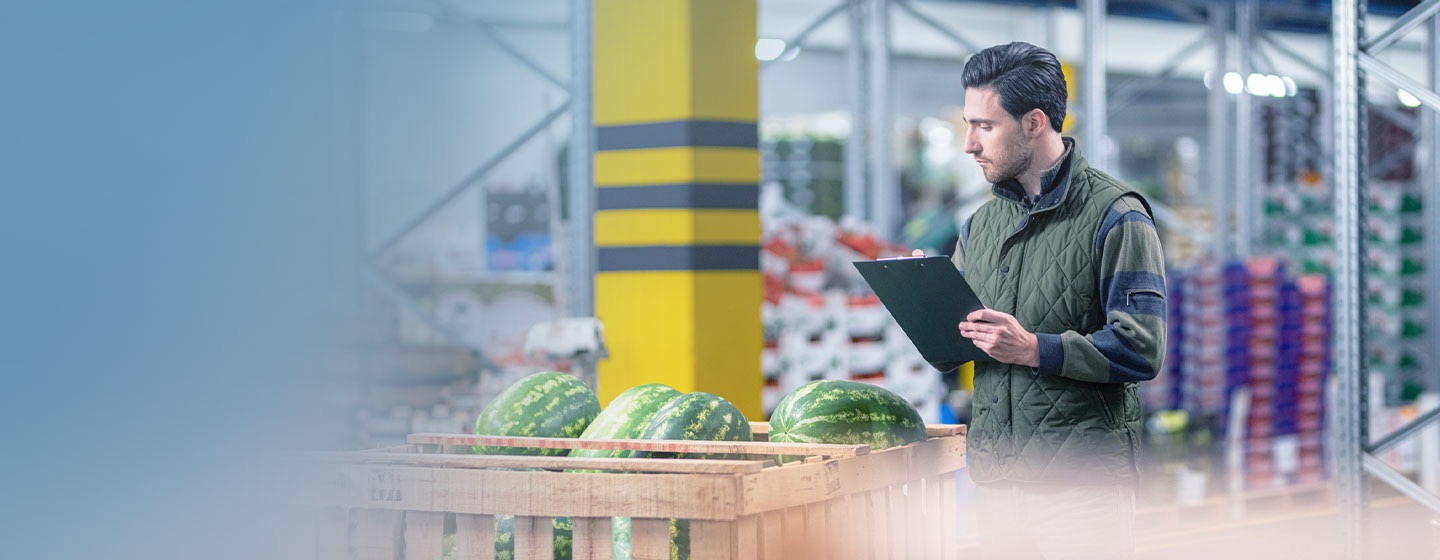 man is writing product quantity in notepad