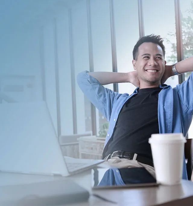 Relaxed man smiling in front of the laptop