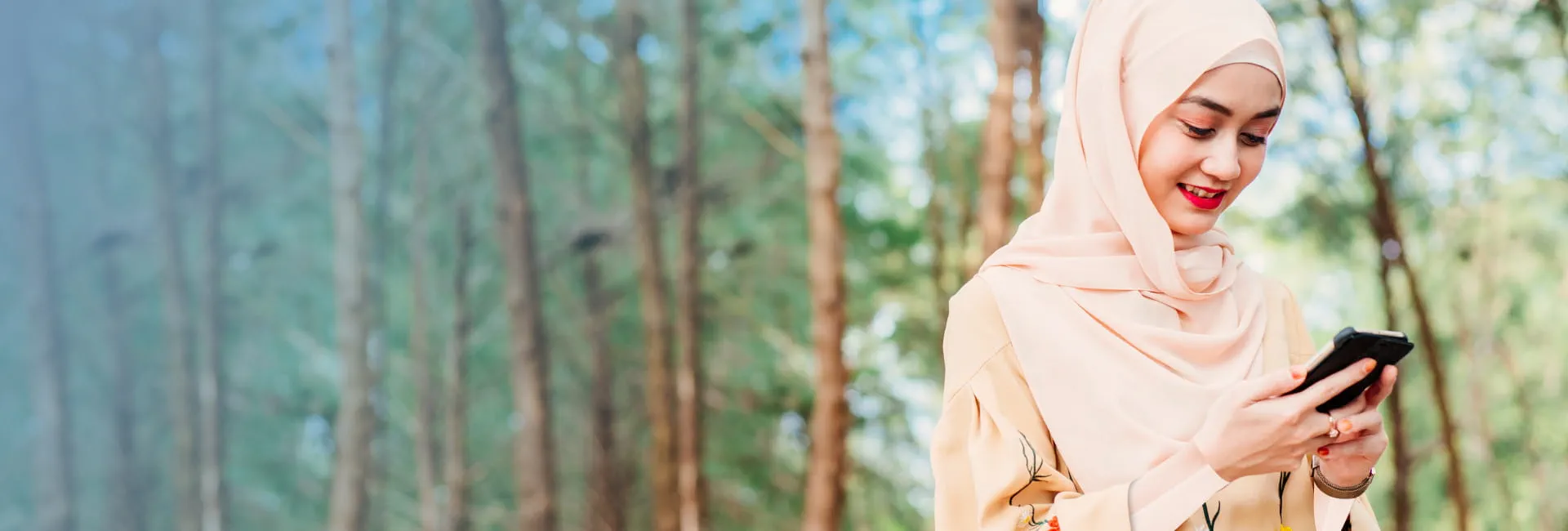 Islamic lady walking in the forest using her phone