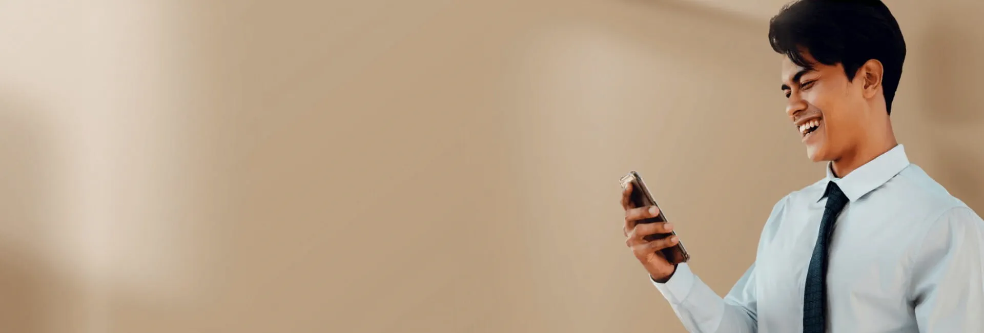 Man laughing while using his phone