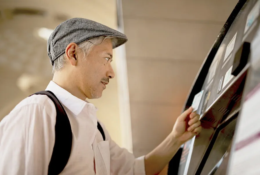 Man inserting a card into an ATM for withdrawal.