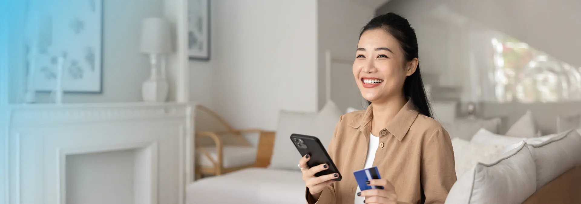 A person holding a credit card and a phone