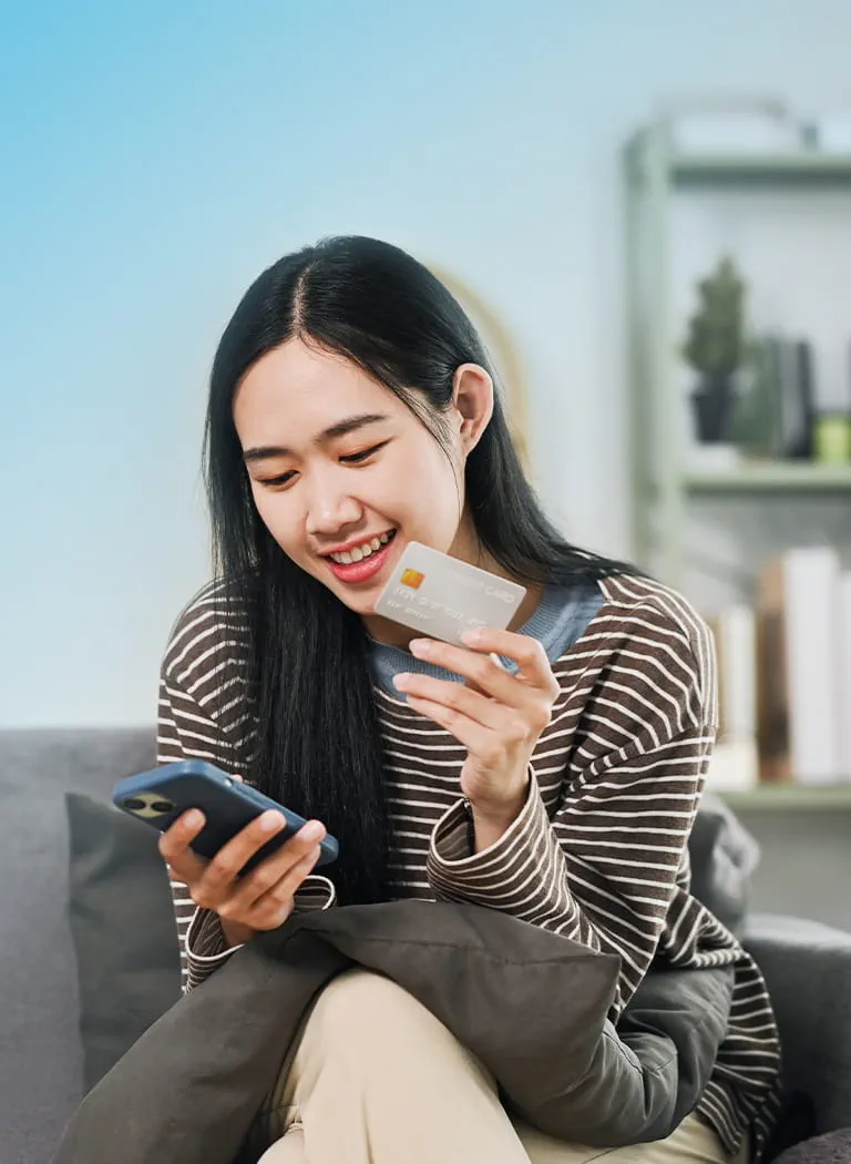 A person holding a credit card and a phone