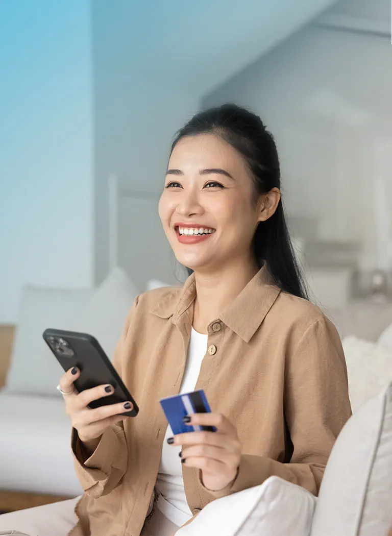 A person holding a credit card and a phone